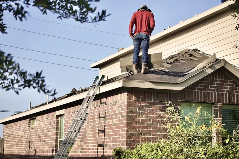 Professional roofer working on a residential roof in Algers Mills